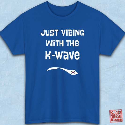 Blue t-shirt flatlay with “Just vibing with the K-Wave” printed on front. Korean pop culture fandom t-shirt by K-Jota
