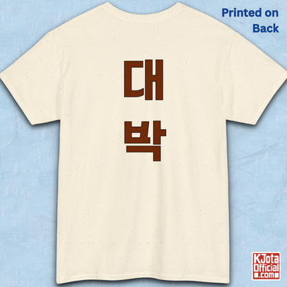 beige t-shirt backside flatlay with “대박” Daebak Korean slang Hangeul text printed in burgundy brown by K-Jota