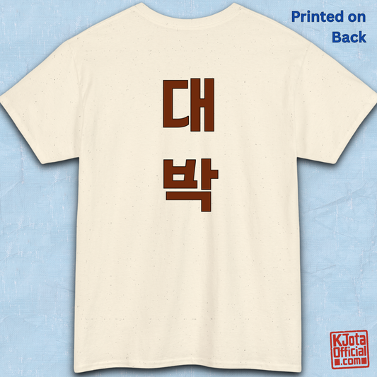 beige t-shirt backside flatlay with “대박” Daebak Korean slang Hangeul text printed in burgundy brown by K-Jota