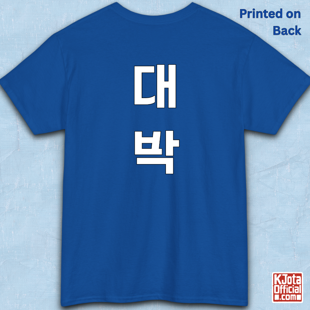 blue t-shirt backside flatlay with “대박” Daebak Korean slang Hangeul text printed in white by K-Jota