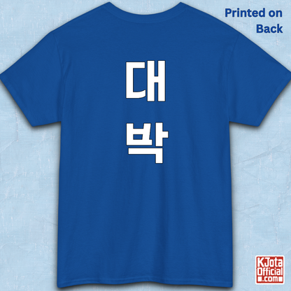 blue t-shirt backside flatlay with “대박” Daebak Korean slang Hangeul text printed in white by K-Jota