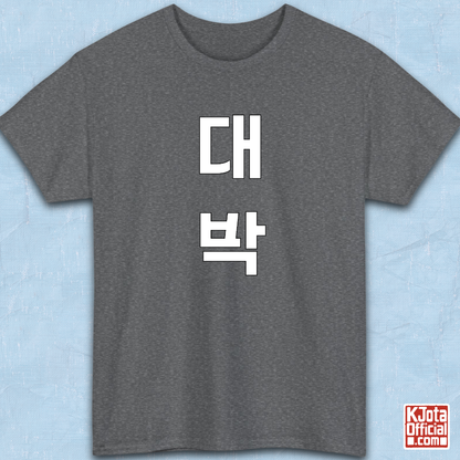 gray t-shirt flatlay with “대박” Daebak Korean slang Hangeul text printed in white by K-Jota