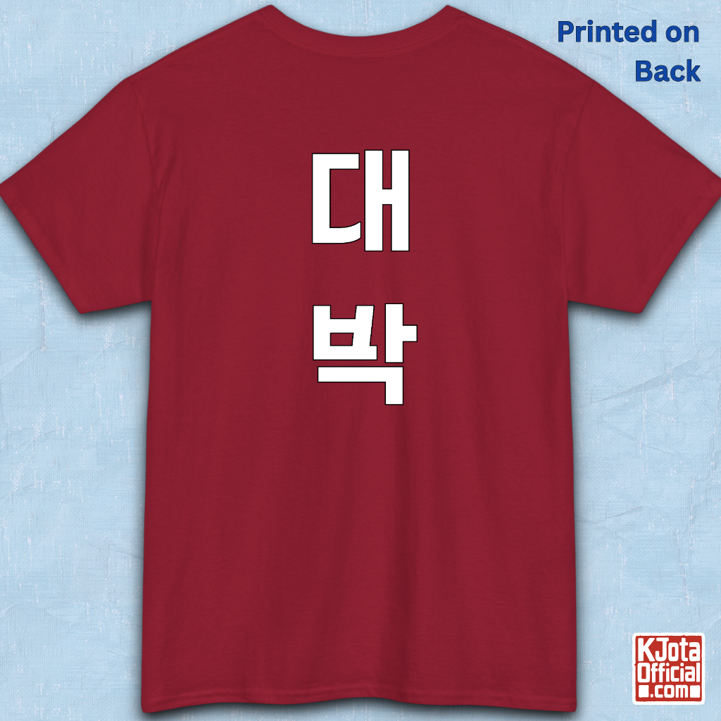 red t-shirt backside flatlay with “대박” Daebak Korean slang Hangeul text printed in white by K-Jota