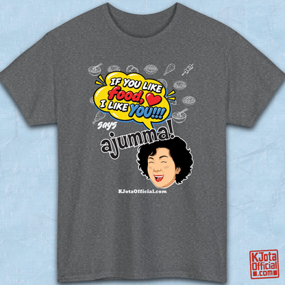 gray t-shirt flatlay with a comic-style yellow speech bubble reading 'If You Like Food, I Like You!!!' above a laughing Korean ajumma illustration and hand-drawn Korean food icons by K-Jota