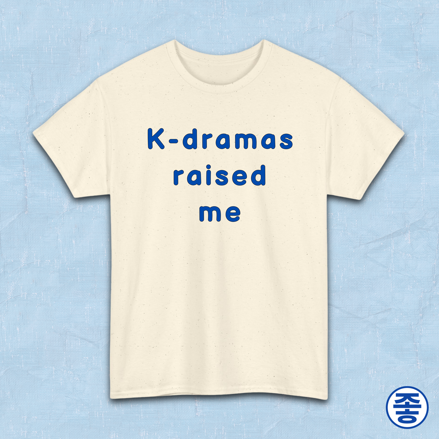 Beige t-shirt for Korean show fans with 'K-dramas raised me' text on a light blue background by Kjota