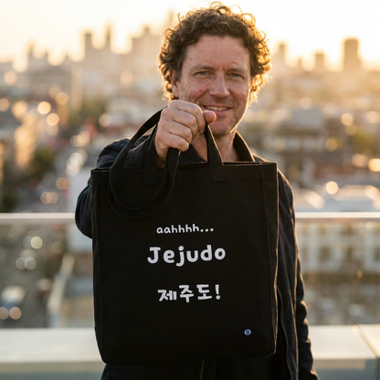 man holding Jeju Island Korea travel 제주도 black canvas tote bag by Kjota