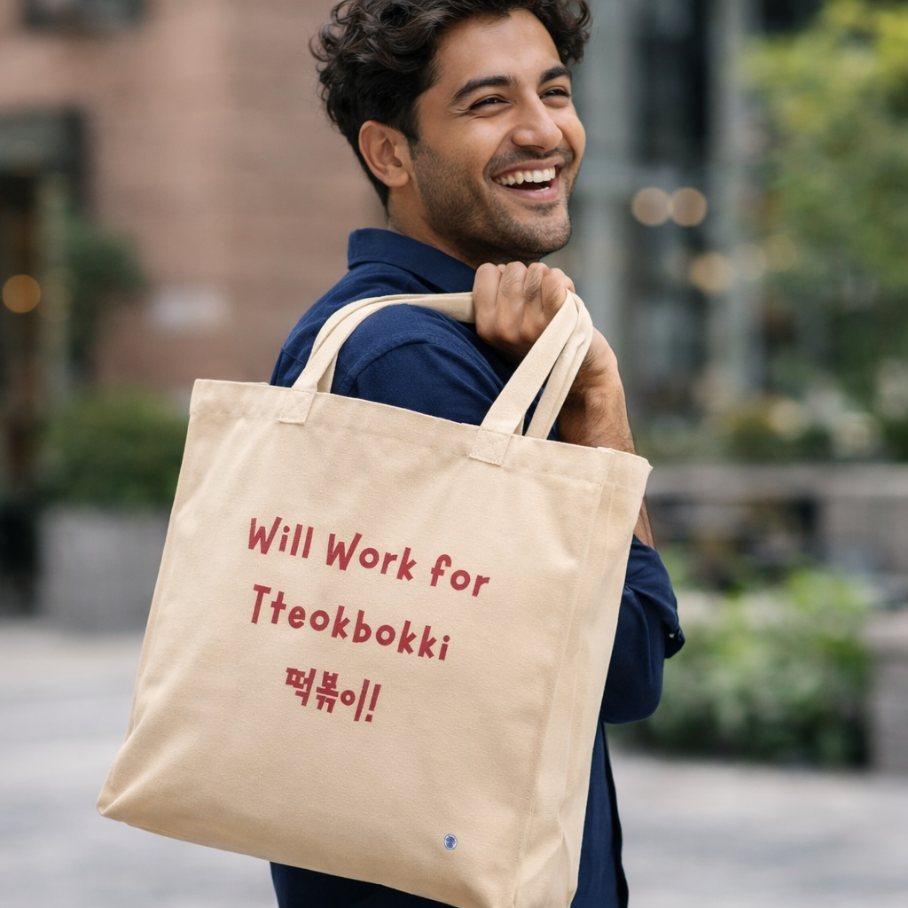 man holding “will work for tteokbokki” Korean street food fan beige canvas tote bag by Kjota