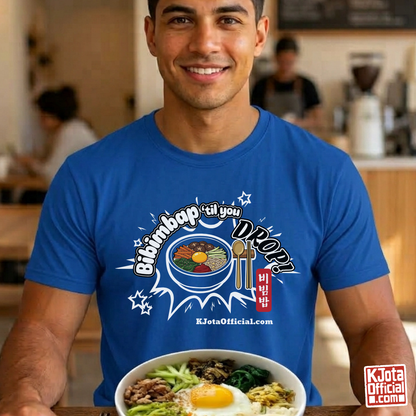 A man wearing a blue t-shirt by K-Jota showing Korean food mixed rice bowl and sitting at a table with a bowl of bibimbap. The graphic features a hand-illustrated bowl of bibimbap with a spoon and chopsticks, and texts “Bibimbap ‘til You Drop 비빔밥” and “KJotaOfficial.com”.