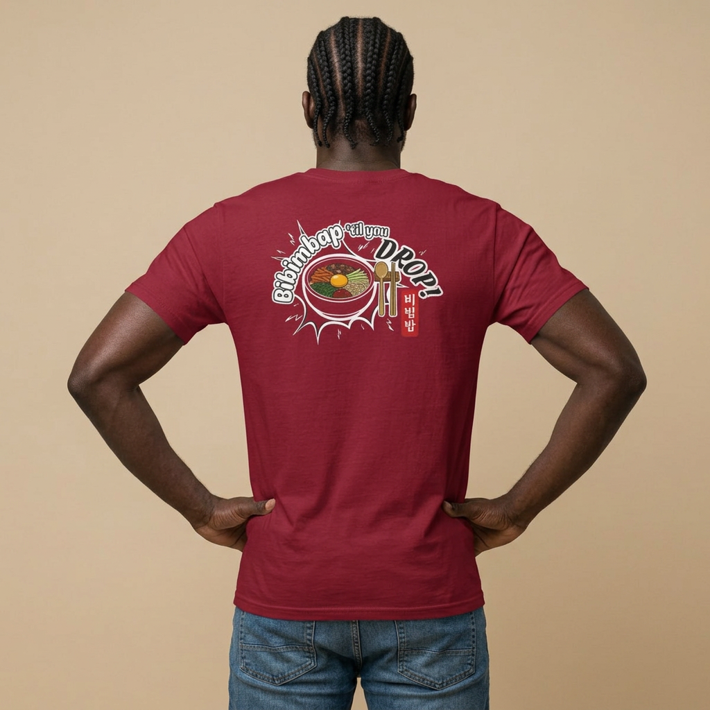 A man viewed from behind wearing a red Korean food fan t-shirt by Kjota with a graphic on the back. The graphic features a bowl of bibimbap with a spoon and chopsticks, and text “Bibimbap ‘til You Drop 비빔밥”