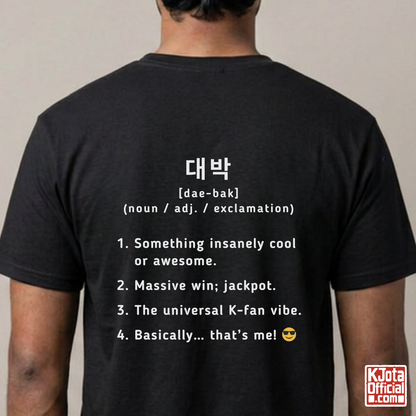 man wearing a black short-sleeve T-shirt shown from the back with white printed Korean text and a dictionary-style definition of Daebak 대박 Korean slang. K-fandom merch by K-Jota
