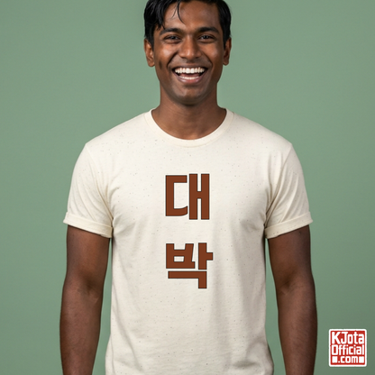 man wearing a beige t-shirt with “대박” Daebak Korean text printed on front by K-Jota