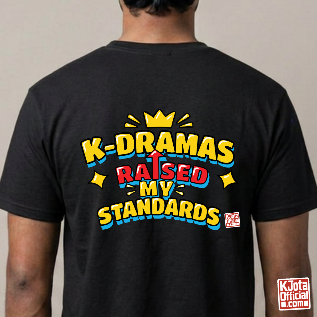 man wearing a black t-shirt with 'K-DRAMAS RAISED MY STANDARDS' printed on the back. Realistic expectations K-fan graphic tee by K-Jota