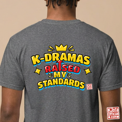 man wearing a gray t-shirt with 'K-DRAMAS RAISED MY STANDARDS' printed on the back. Realistic expectations K-fan graphic tee by K-Jota