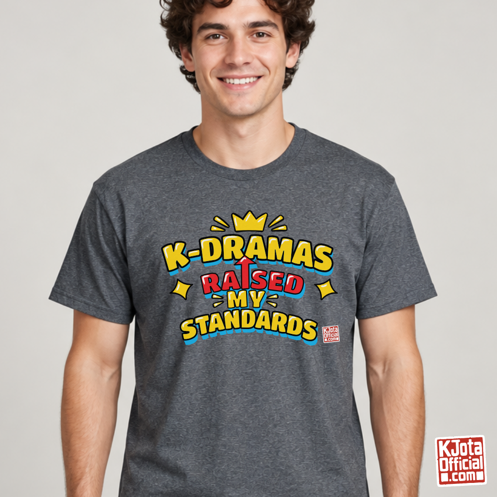 man wearing a gray t-shirt with 'K-DRAMAS RAISED MY STANDARDS' printed on the front. Realistic expectations K-fan graphic tee by K-Jota