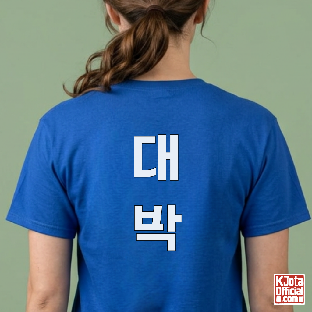 woman wearing a blue t-shirt with “대박” Daebak Korean text printed on back by K-Jota