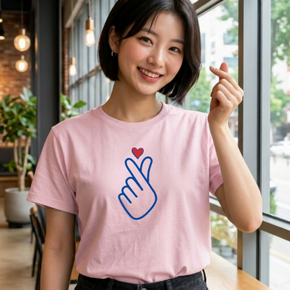 woman wearing finger heart Korean saranghaeyo I love you K-pop Hallyu fan t-shirt pink by K-Jota and making finger heart gesture at a modern cafe
