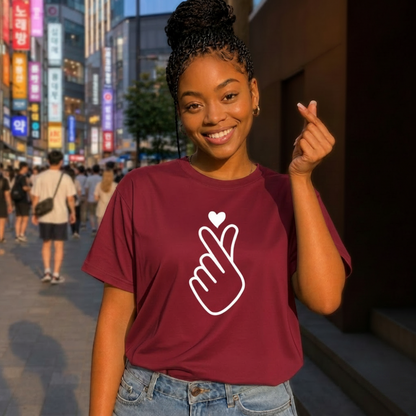 woman wearing finger heart Korean saranghaeyo I love you K-pop Hallyu fan t-shirt red by K-Jota and making finger heart gesture in Korean city street