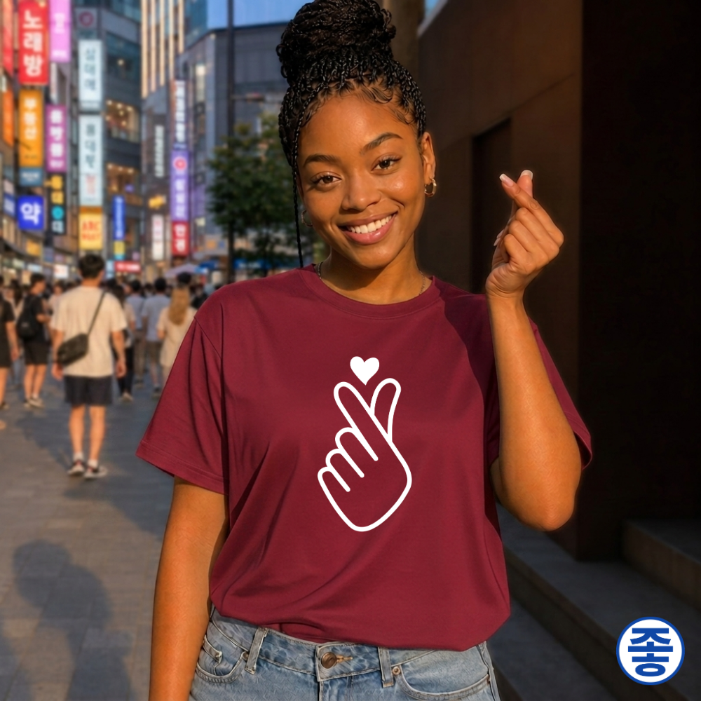 woman wearing finger heart Korean saranghaeyo K-pop Hallyu fan t-shirt red by Kjota and making finger heart gesture in Korean city street