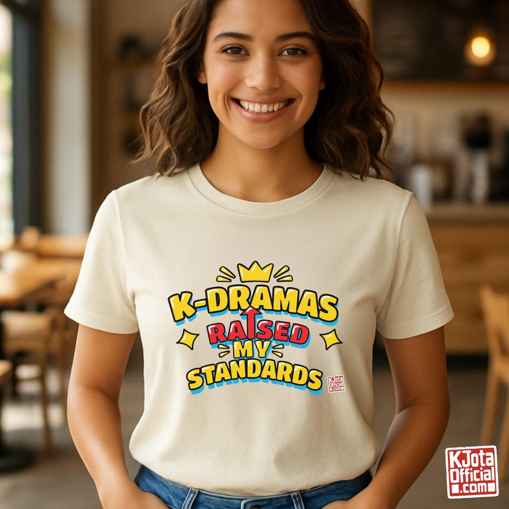 woman wearing a beige t-shirt with 'K-DRAMAS RAISED MY STANDARDS' printed on the front. Realistic expectations K-fan graphic tee by K-Jota